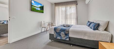 A modern bedroom with a bed, a desk, and a chair.