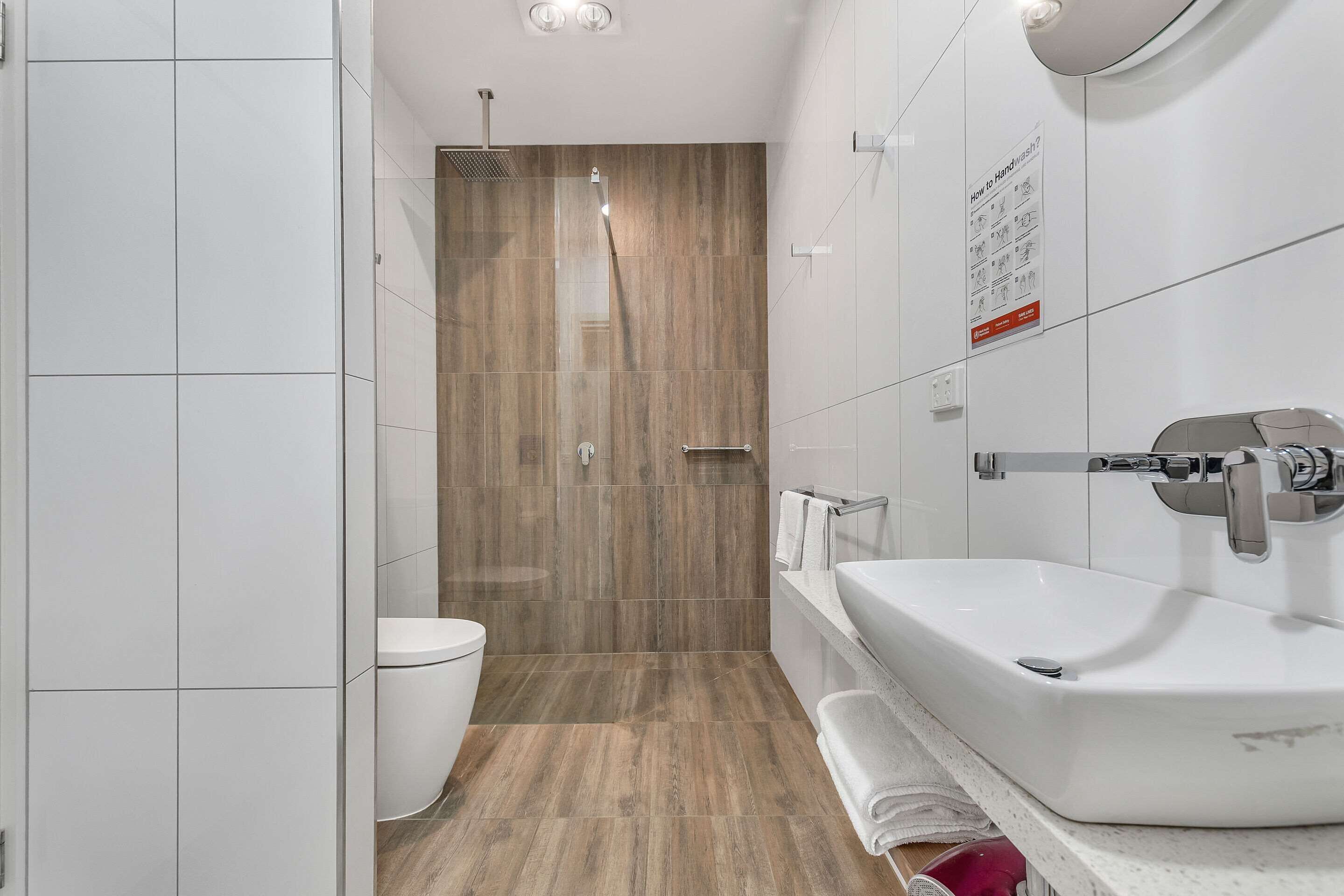 Un baño moderno con ducha, inodoro y lavamanos.