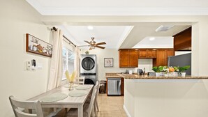 Una cocina moderna con armarios de madera, horno empotrado e isla central con pileta.