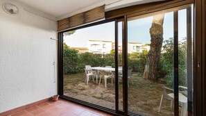 A room with a sliding glass door leading to an outdoor patio area with a table and chairs.