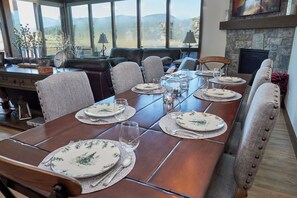 Une salle à manger avec une longue table en bois, dressée pour six personnes, entourée de chaises rembourrées.
