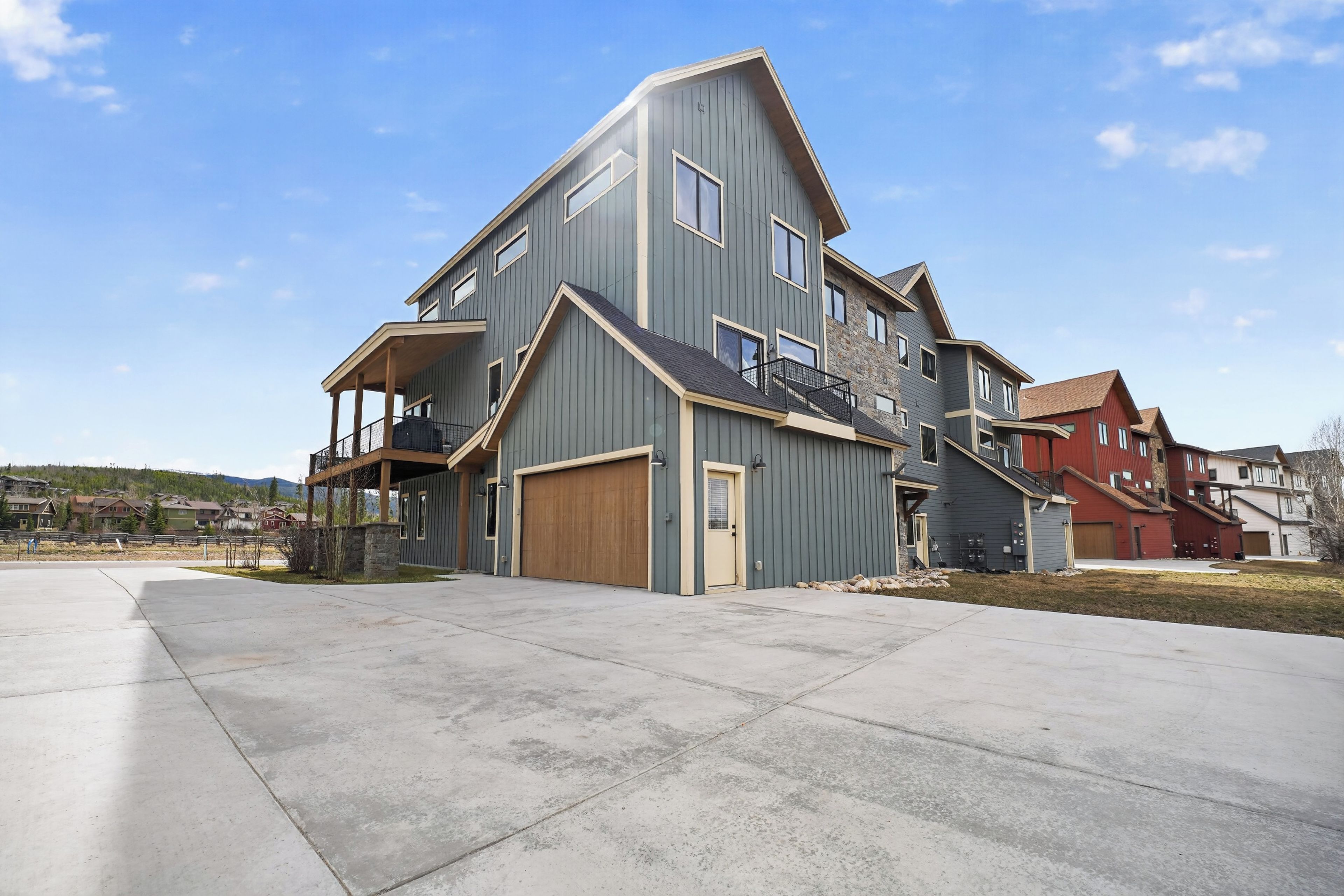 A multi-story residential building with a garage, a covered porch, and a small balcony.
