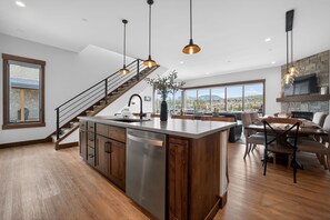 A modern kitchen with a central island, stainless steel appliances, and pendant lighting. - New, modern mountain retreat for several families 8 min from ski resort. (Fraser)