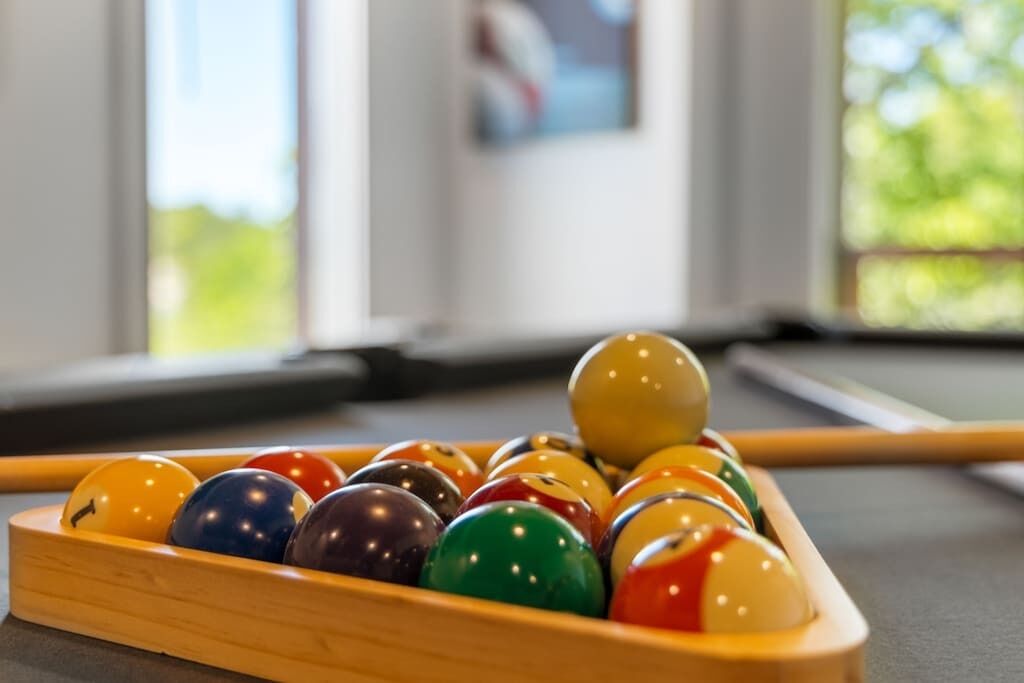 Une table de billard avec un jeu de billes de différentes couleurs.