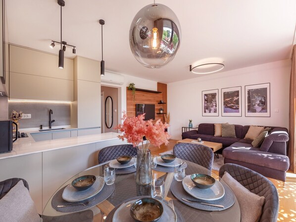 Enjoy a stylish living space with a central dining area, contemporary kitchen, and comfortable seating.