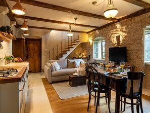 Cozy living space with a wooden staircase, comfortable sofa, and dining area.
