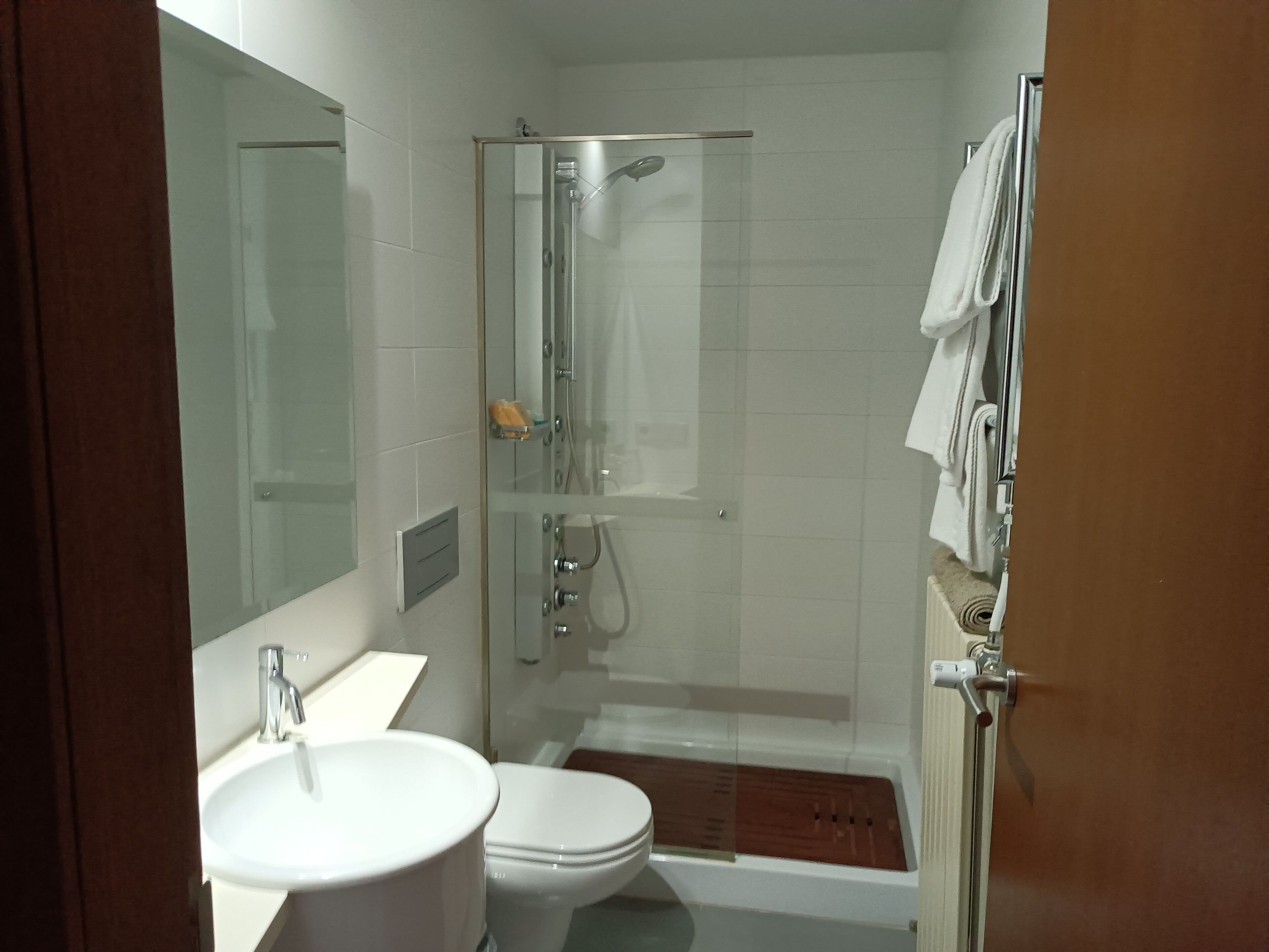 Un bany amb dutxa trencada per vidre, vàter i rentapel.