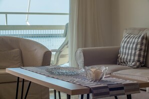 Panoramic Apartment | Living area | 27-inch flat-screen TV with cable channels, TV - Seafront Apartment Grace (Kalamata)