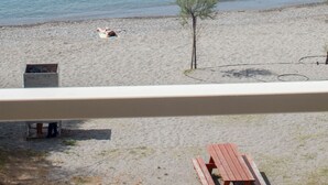 A beach with a wooden bench and a picnic table. - Seafront Apartment Grace (Kalamata)