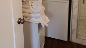 Un cuarto de lavado con toallas apiladas, un horno y un lavamanos.