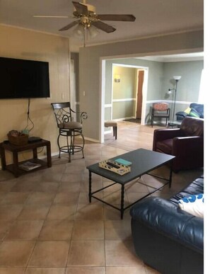 Relax in this cozy living space with a flat-screen TV, comfortable sofa, and coffee table.