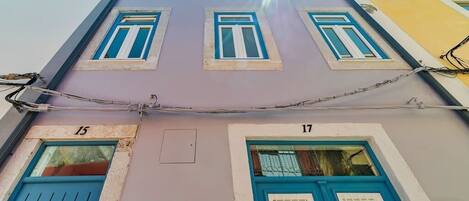 A building with two visible doors labeled 15 and 17, and a barred window above.