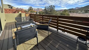 A deck with outdoor furniture, a view of red rock formations, and a clear sky. - Sedona Sky View (Sedona)