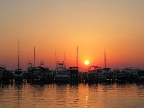 Un puerto deportivo con barcos amarrados al atardecer.