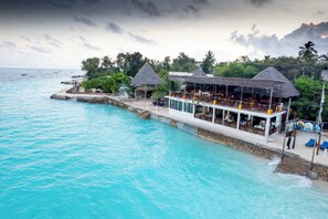 A beachfront hotel with overwater bungalows, a pool, and a beach bar. - Double A Nungwi Beach Hotel – Beach Front (Nungwi)