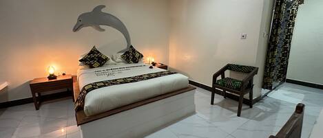 A neatly arranged bedroom with a bed, bedside tables, a chair, and a wall decoration.