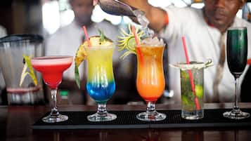 Un barman prépare des cocktails colorés, en y ajoutant des pailles et des décorations.
