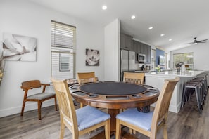 A modern kitchen with a central island, wooden chairs, and a dining table. - *Sea Salt by the sand* Walk to beach/seafood/fishing (Gulfport)