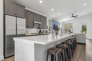 Enjoy cooking in this well-equipped kitchen with a large island, bar stools, and ample counter space.