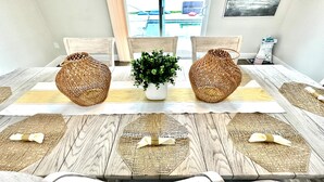 Una mesa de comedor con dos cestas tejidas, una planta en maceta y individuales tejidos.