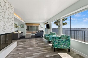 A spacious balcony with a view of the water, furnished with a sofa, chairs, and a fireplace. - Spectacular Bayfront Oasis! Exceptional views and PRIME location! (San Diego)