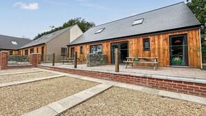 Een gebouw met een houten gevel, een stenen muur en een kiezelhof.