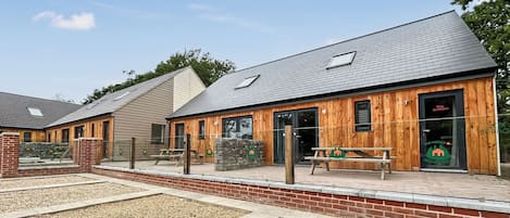 Een gebouw met een houten gevel, een stenen muur en een kiezelhof.