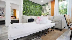 A modern hotel room with a bed, a sofa, a green wall, and a window with curtains. - 28 Guest - 4 Kitchens. Jungle Retreat in Heart Wynwood (Miami)