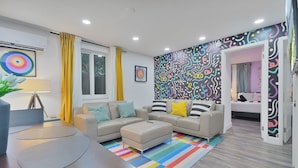 A modern living room with a sofa set, a coffee table, and a colorful striped rug. - 28 Guest - 4 Kitchens. Jungle Retreat in Heart Wynwood (Miami)