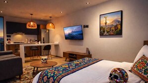 A hotel room with a bed, a desk, a chair, a TV, and a painting on the wall. - Be Local Lofts & Coworking (Mexico City)