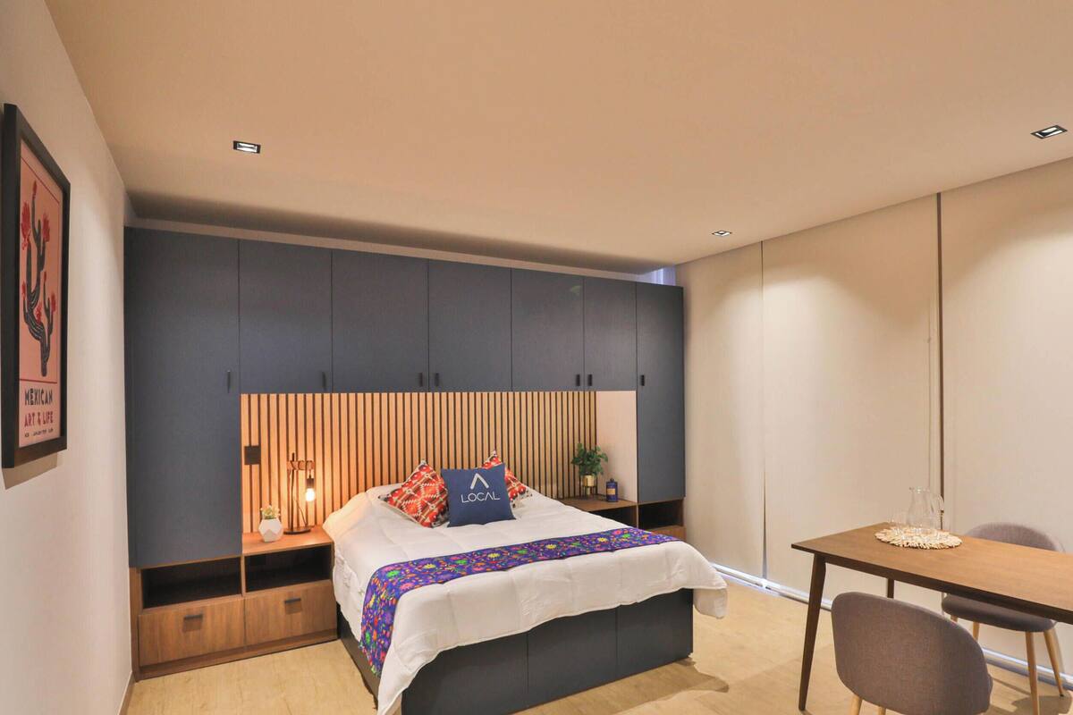 Ein modernes Schlafzimmer mit Bett, Nachttischen, Schreibtisch und Stuhl.