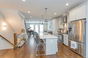 Enjoy cooking in this well-equipped kitchen with a central island, stainless steel appliances, and bar stool seating.