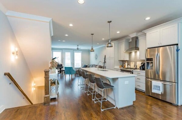 Enjoy cooking in this well-equipped kitchen with a central island, stainless steel appliances, and pendant lighting.