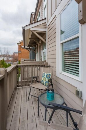 Enjoy a peaceful moment on this balcony with a glass table and comfortable chair.