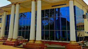A building with a classical architectural style, featuring a central entrance with columns and a flat roof. - T Golden Villa Hotel (Enugu)