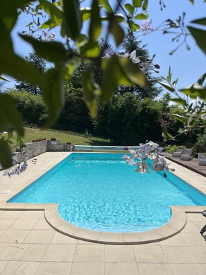 A rectangular swimming pool with a tiled deck surrounding it. - La Colline de Tilleul - beautiful cottage near Aubeterre with pool 4 Star Rated! (Saint-Romain)