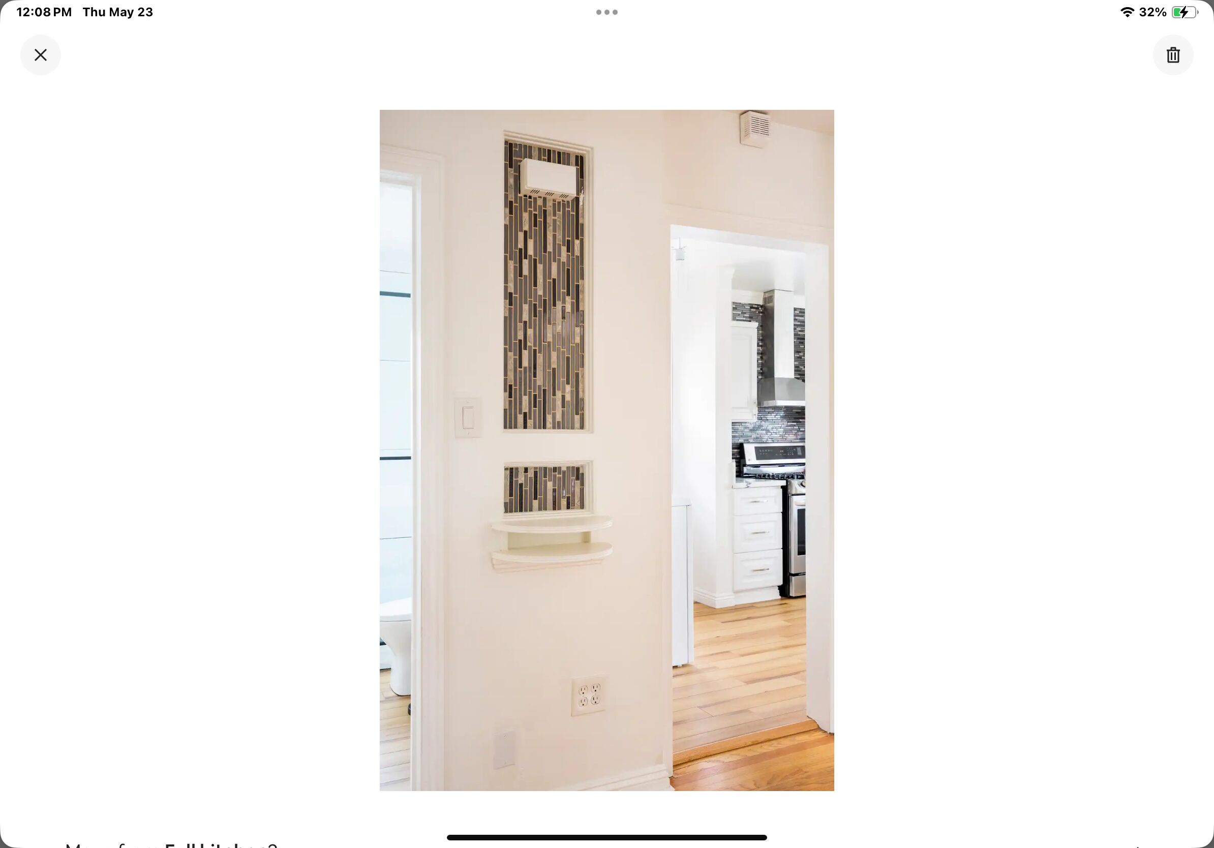 A hallway with a white door leading to a kitchen area.