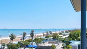 Blick auf die Küste mit Strand, blauem Himmel und Wohnhäusern.