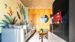 A modern living room with a sofa, a coffee table, and a TV mounted on the wall. - Deluxe Apartments in Palermo - by BueRentals (Buenos Aires)