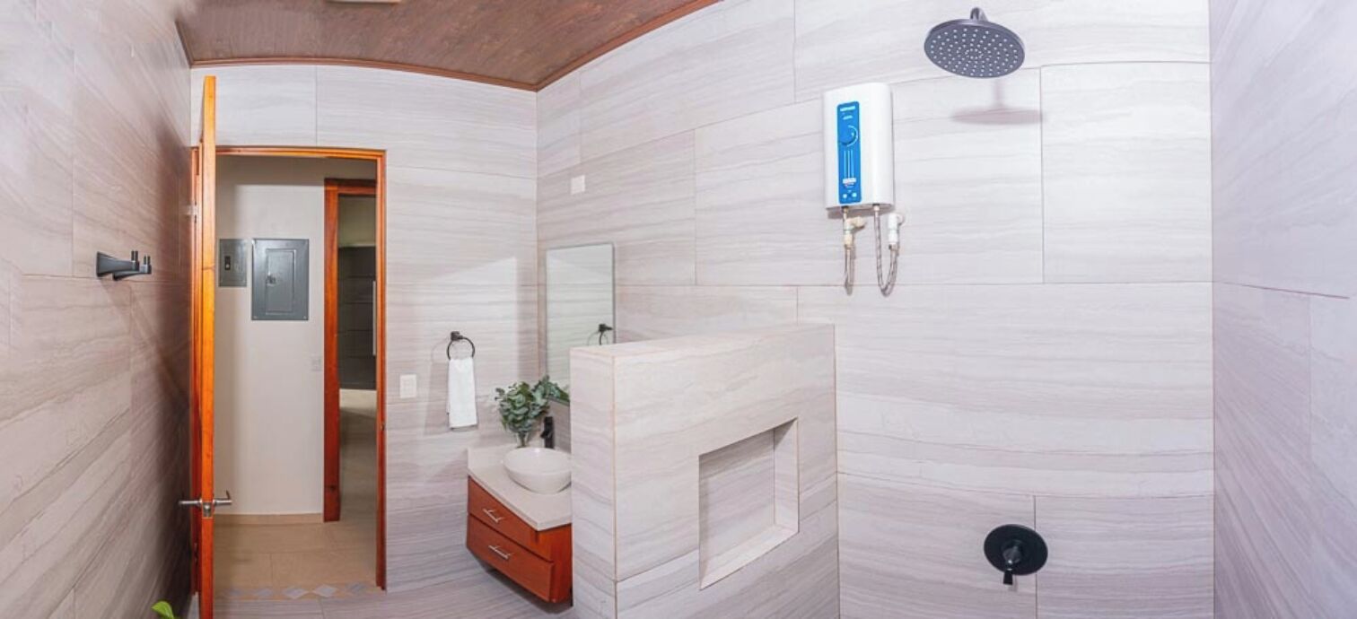 A modern bathroom with a shower, a toilet, and a sink.