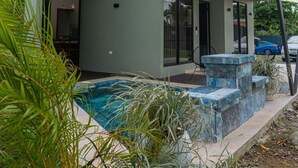 A modern house with a swimming pool, covered patio, and a large glass ceiling. - Hermosa Villa con Jacuzzi, e Hidromasaje en el Centro de la Fortuna (La Fortuna)