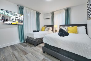 A hotel room with two beds, a mirror, and a view of a street scene. - 4 to 14 Guests, 2 Kitchens, Jungle Retreat BBQ Patio (Miami)