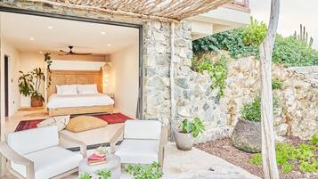 A bedroom with a bed, a ceiling fan, and a view of the garden.