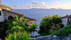 A coastal view with a stone staircase leading to a thatched-roof building, overlooking the sea. - The Aerial, BVI (East End)