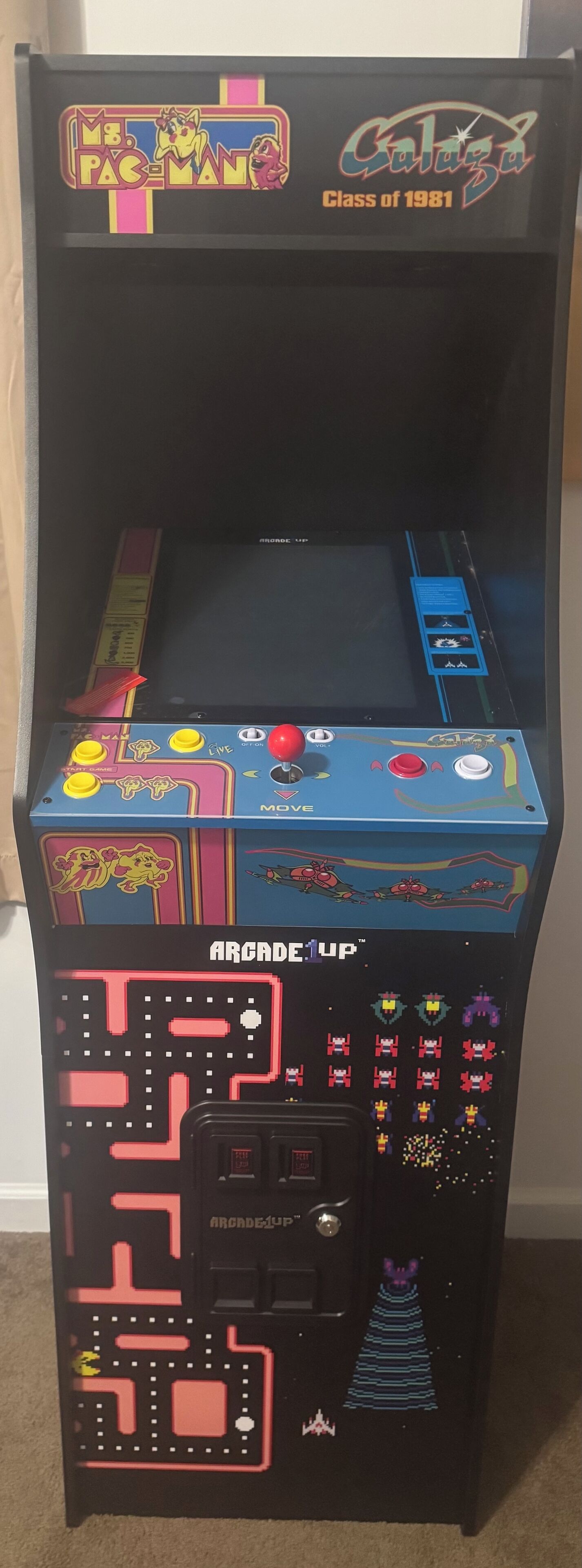 Una máquina arcade antigua, concretamente el juego 'Pac-Man' de 1981, con un diseño colorido y un panel de control con joystick.