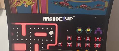 Una máquina arcade antigua, concretamente el juego 'Pac-Man' de 1981, con un diseño colorido y un panel de control con joystick.