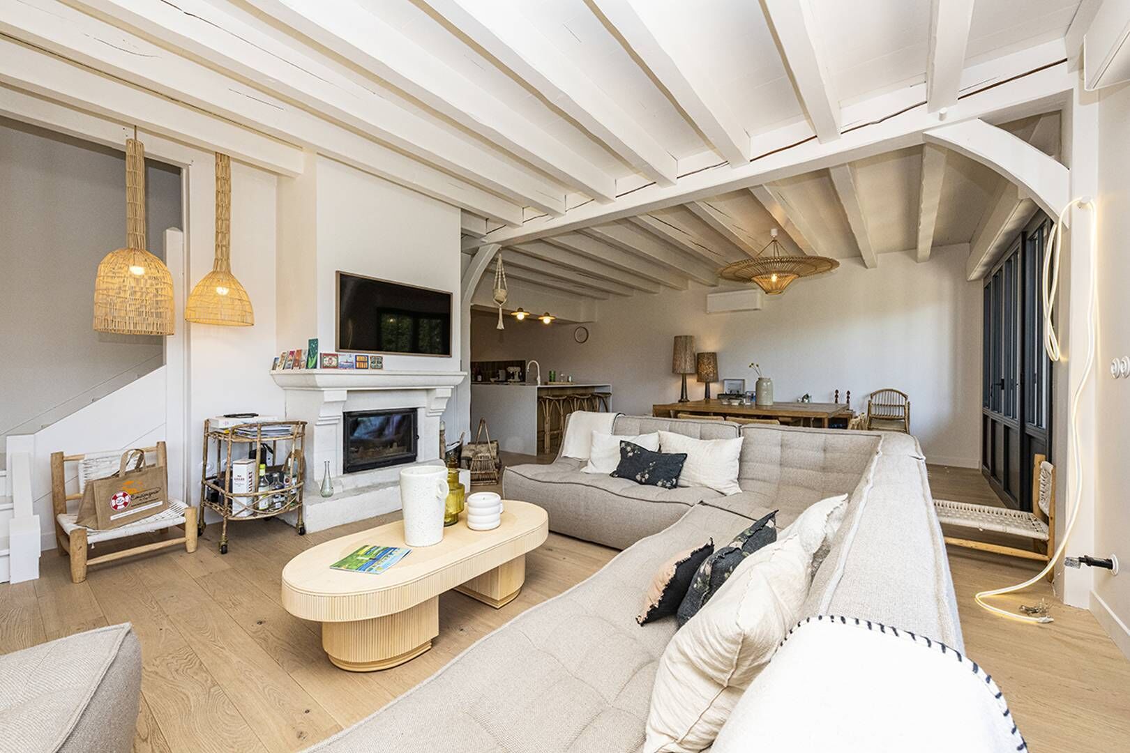 Ein geräumiges Wohnzimmer mit Kamin, einer Couch, einem Couchtisch und einem Essbereich.