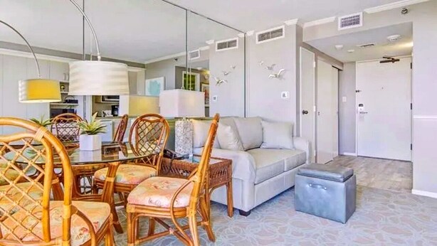 Un salon moderne comprenant un coin repas, un canapé et une petite table.