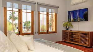 A bedroom with a bed, a wooden cabinet, and a TV on the wall. - BeautifulHome, in front of the community pool By Casago (Loreto)