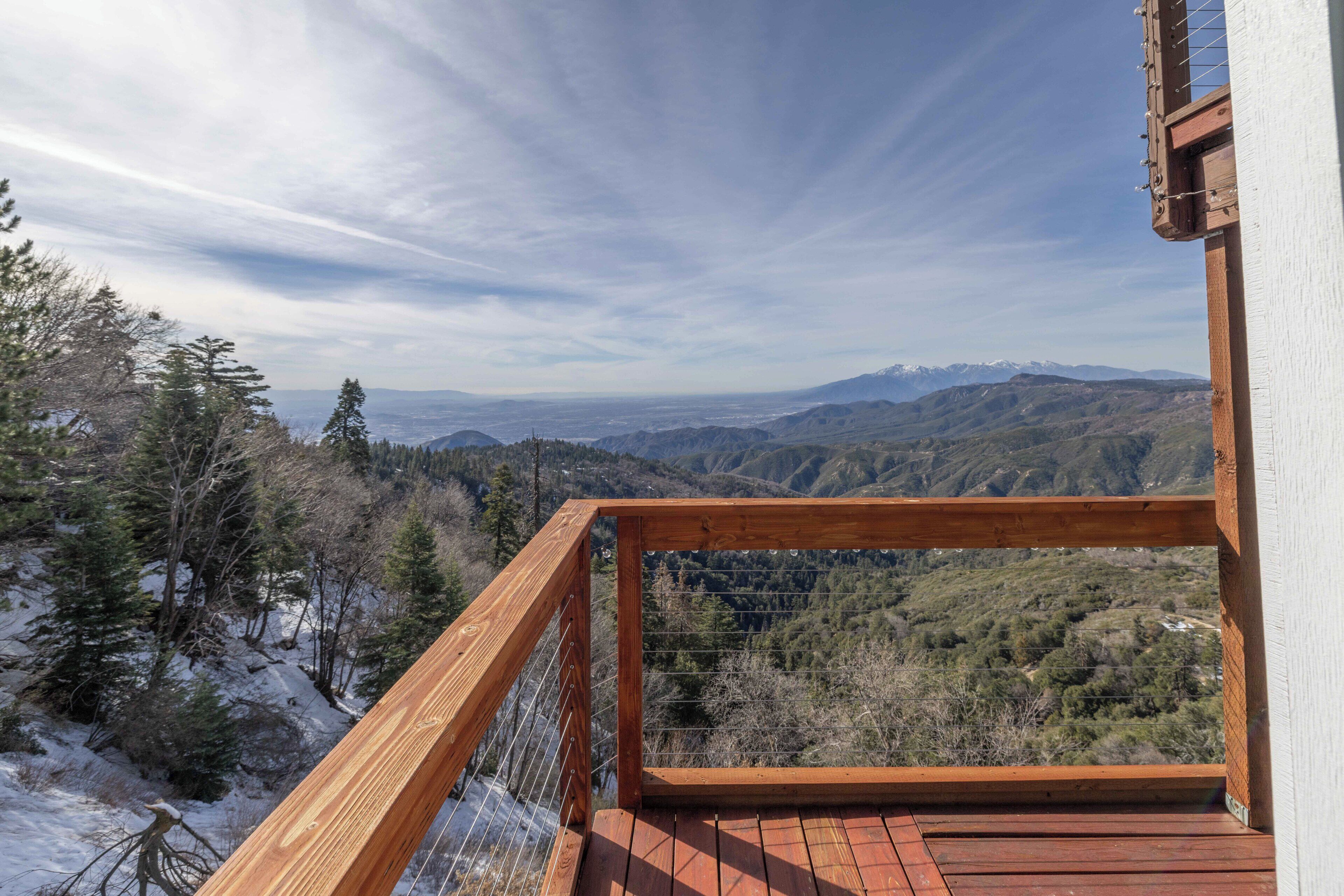 Una terraza de madera con vistas a un paisaje montañoso.
